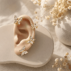 Gold butterfly stud earrings with crystal details, displayed on ear model with dried flowers