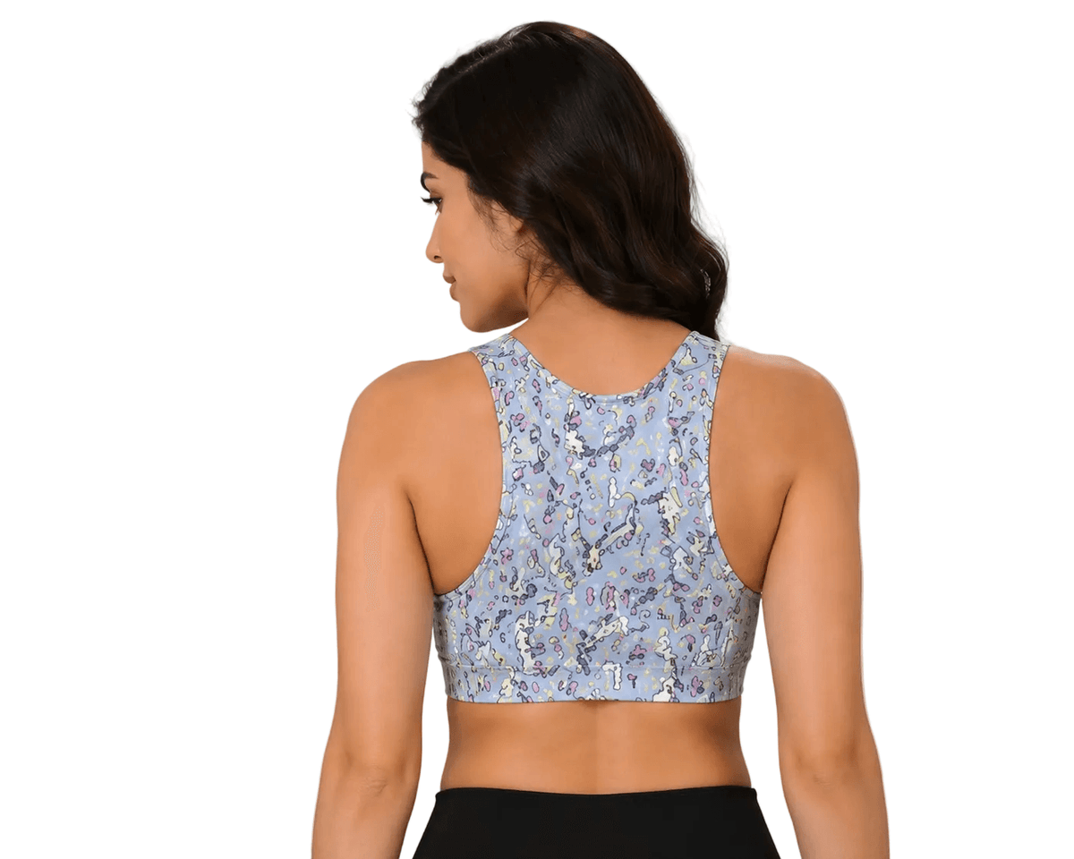 Woman wearing floral print sports bra, back view, with black leggings and dried pampas grass decor