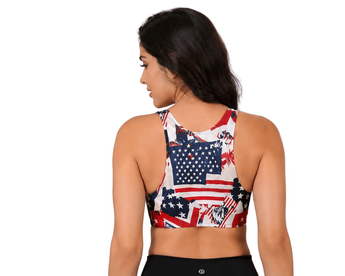 Women's sports bra with American flag print, back view, paired with black leggings for fitness wear.