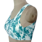 Teal and white tie-dye sports bra with racerback design, displayed on mannequin