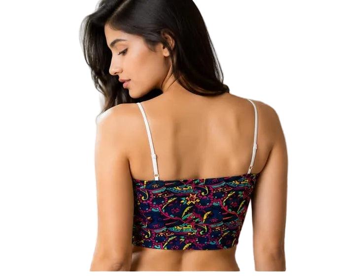 Woman wearing colorful patterned crop top with thin straps, back view near window